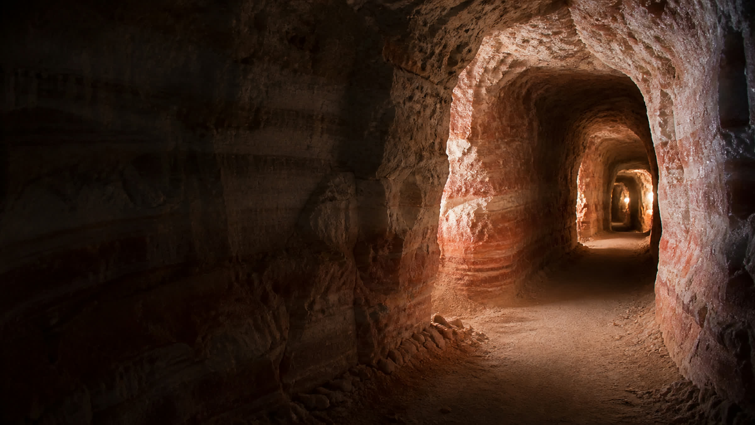 Illuminated tunnel cut through pink rock salt in the Punjab Salt Range